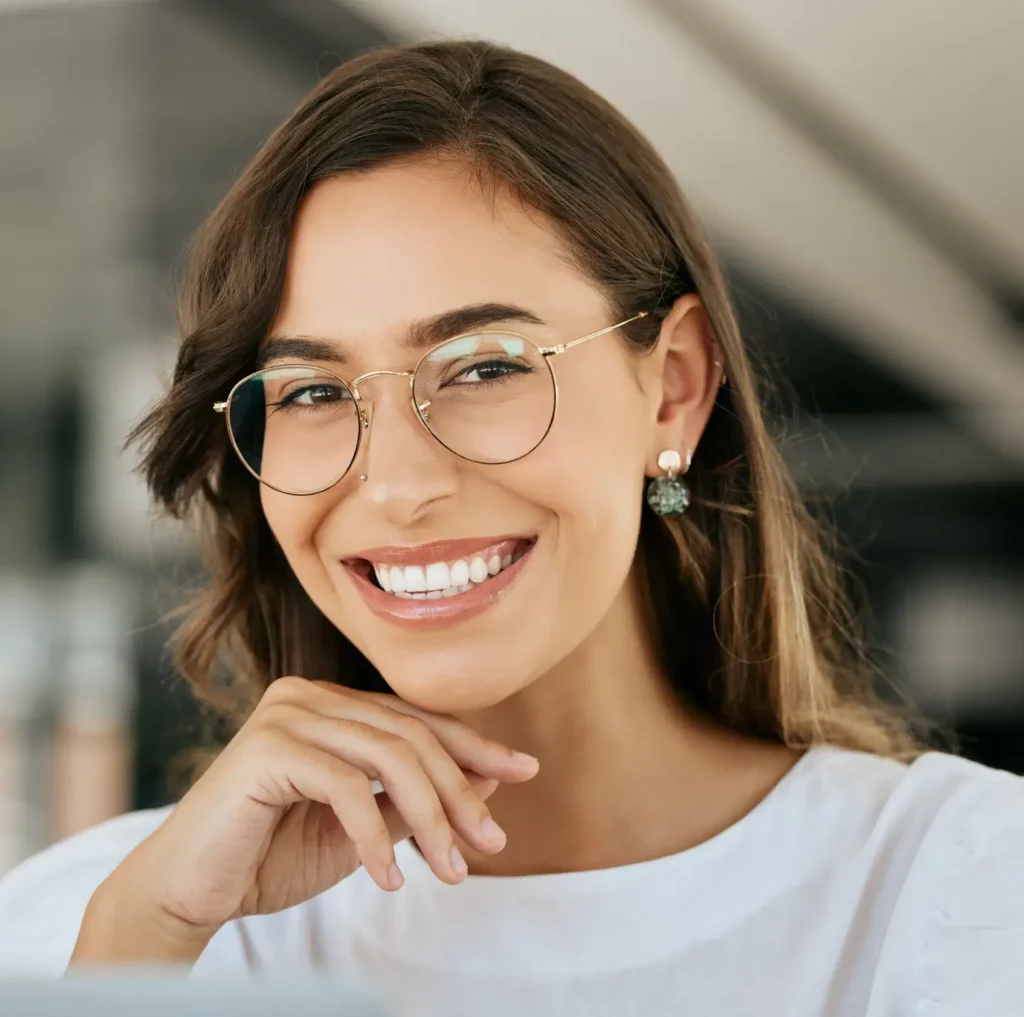 A smiling woman with radiant white teeth and glasses, highlighting the results of Cosmetic Dentistry at Laughlin Dental