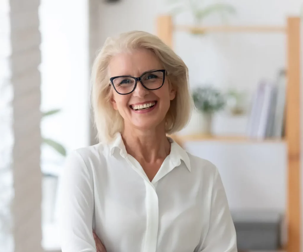 A confident, smiling woman with bright teeth, possibly a patient satisfied with Dental Implants at Laughlin Dental