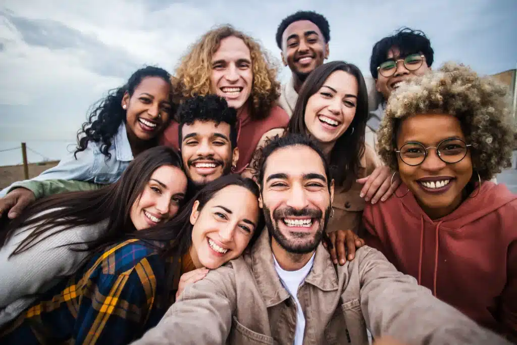 A diverse group of smiling young adults taking a selfie, perhaps discussing Tooth Sealants at Laughlin Dental
